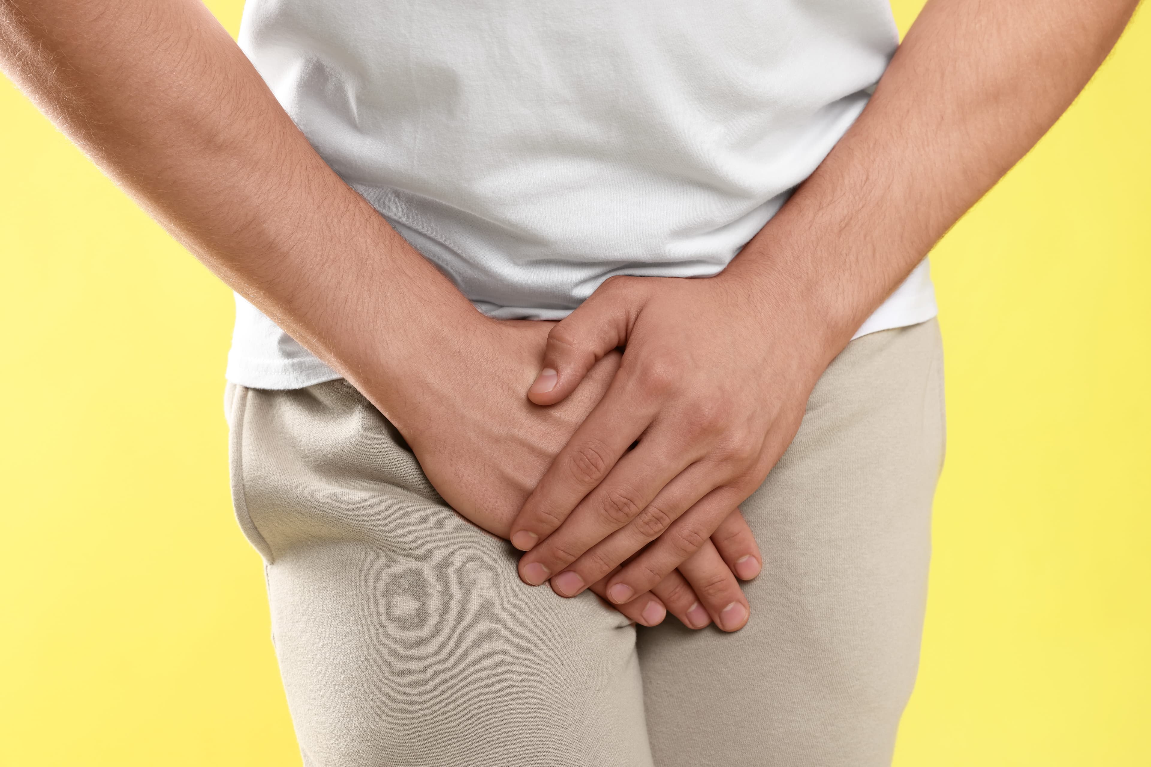Man holding his groin in discomfort, illustrating the symptoms of an infection that doxycycline can treat.