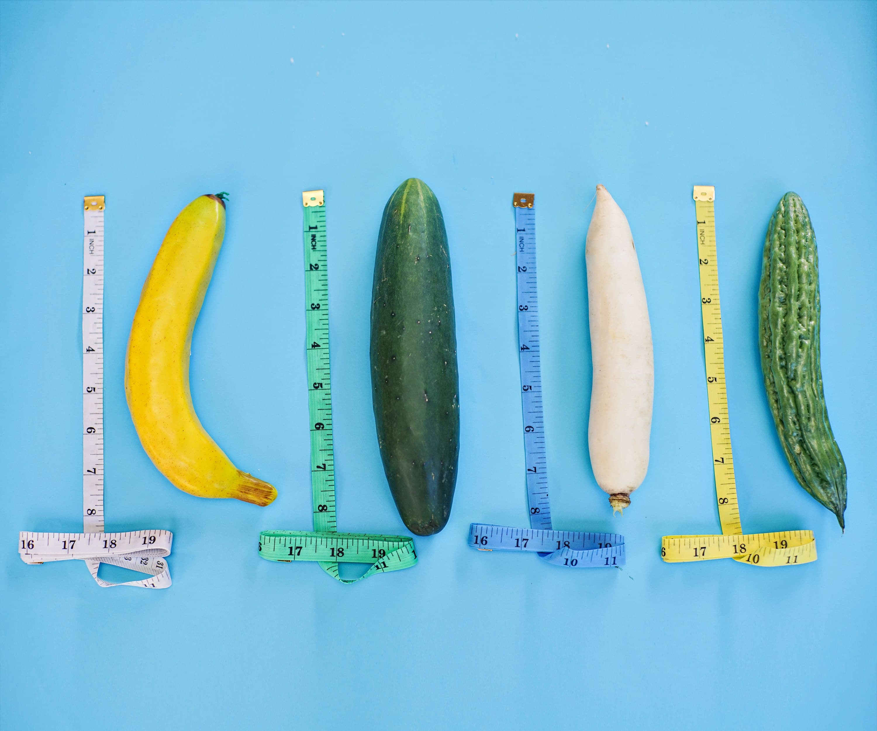 A banana, cucumber and other fruit and veg beside tape measures, illustrating average penis size in the UK